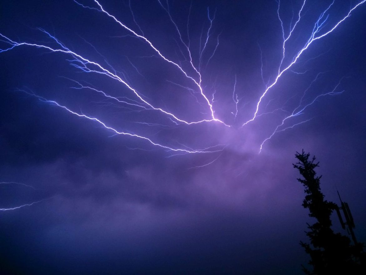lightning striking through dark storm clouds